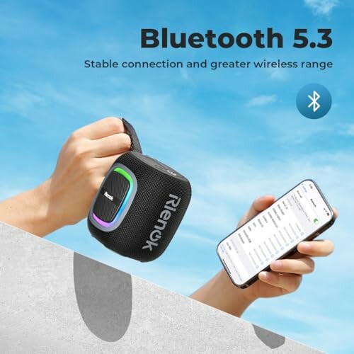 Hands holding a Bluetooth speaker and a smartphone, showcasing Bluetooth 5.3 connectivity.