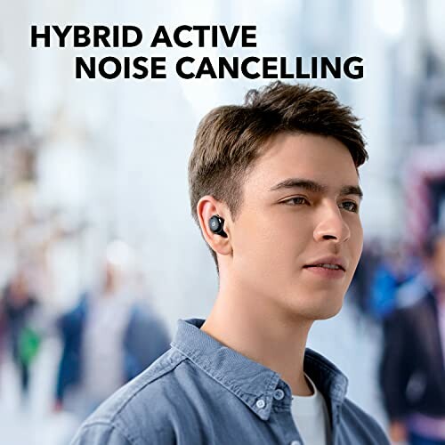 Person wearing hybrid active noise cancelling earbuds in a city setting.