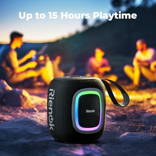 Portable speaker with colorful lights near a campfire setting