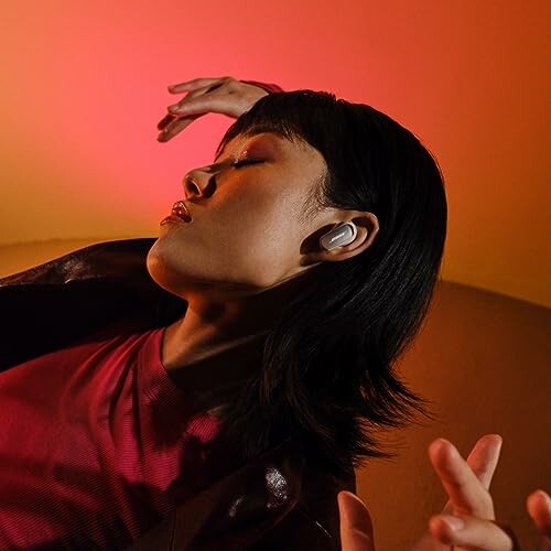 Woman enjoying music with earbuds in a vibrant setting.